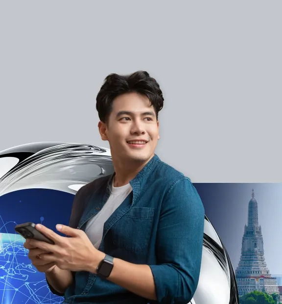 A young man uses a smartphone, with a Bangkok skyline and temple backdrop