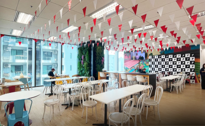 A bright, colorful office cafeteria with festive bunting decor