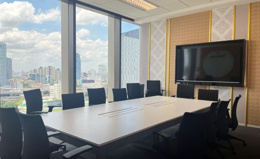 A bright, modern conference room with large city-view windows.